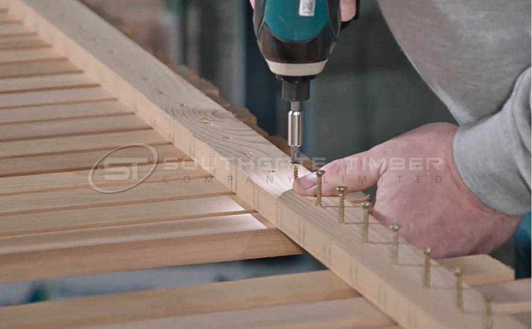 Western Red Cedar timber fence being installed in winter, showing boards fixed to fence rails with screws during cold weather.